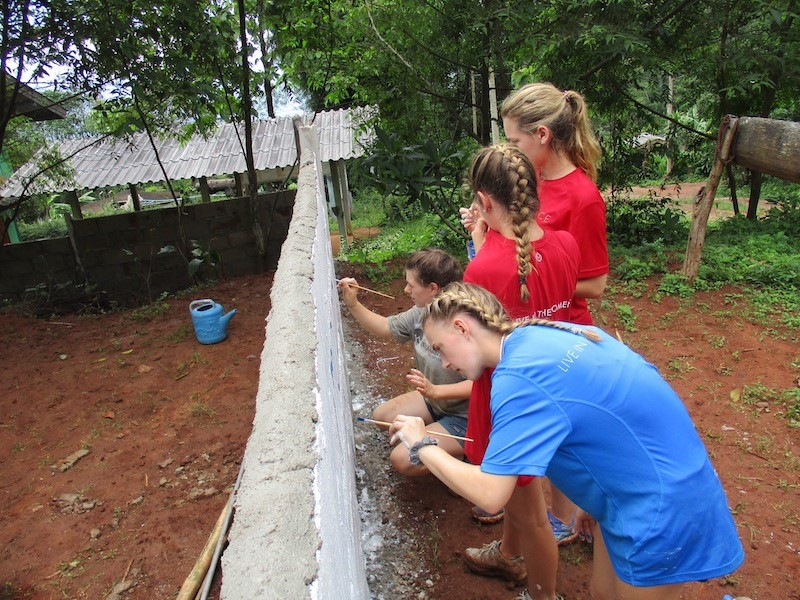 Young people painting a wall
