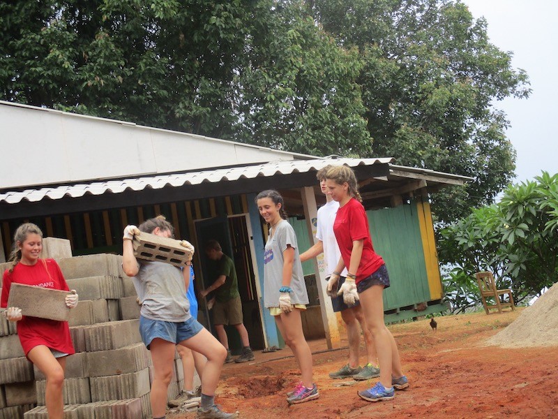 Young women carrying building material
