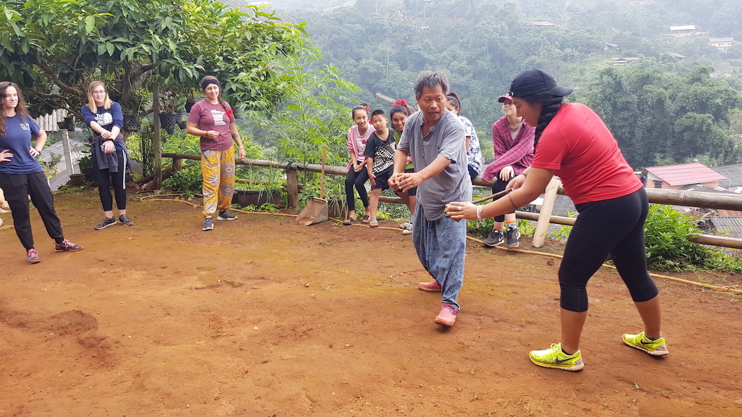 Local guide teaching local game to girl