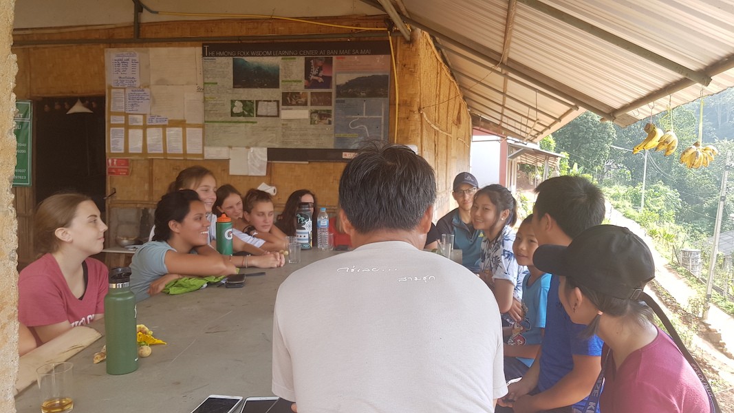 Students and local children at a table